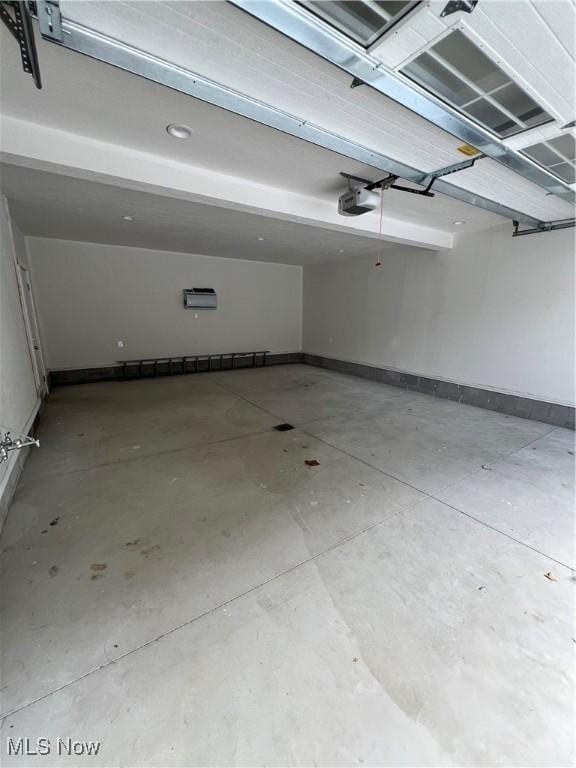 garage featuring a garage door opener and a wall unit AC