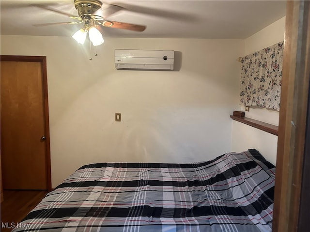 bedroom with ceiling fan, hardwood / wood-style floors, and a wall mounted air conditioner