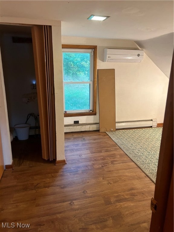 hallway with baseboard heating, dark hardwood / wood-style flooring, and a wall mounted AC