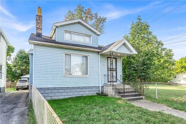 bungalow with a front lawn, fence, and a chimney