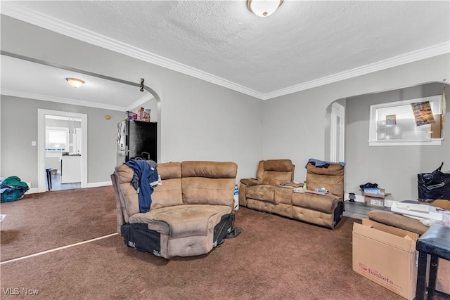 carpeted living room featuring crown molding, arched walkways, and a textured ceiling