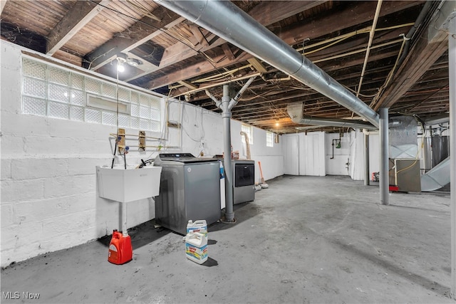 basement with washing machine and dryer, sink, and heating unit