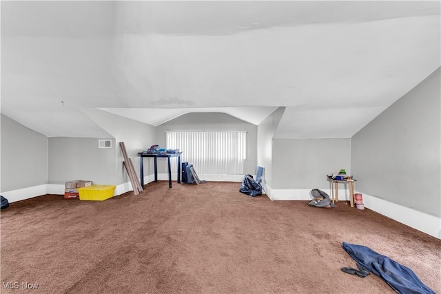 interior space with baseboards, visible vents, carpet, and lofted ceiling