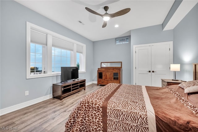 bedroom with light hardwood / wood-style floors, ceiling fan, and a closet