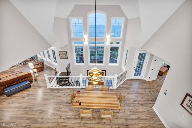 living room with wood-type flooring, a notable chandelier, and a towering ceiling