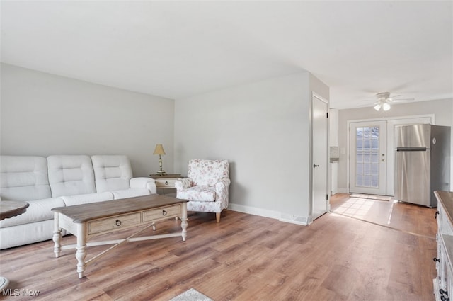 living room featuring light hardwood / wood-style flooring and ceiling fan