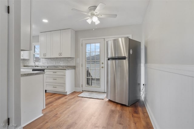 kitchen featuring white cabinets, stainless steel refrigerator, light wood-type flooring, and ceiling fan