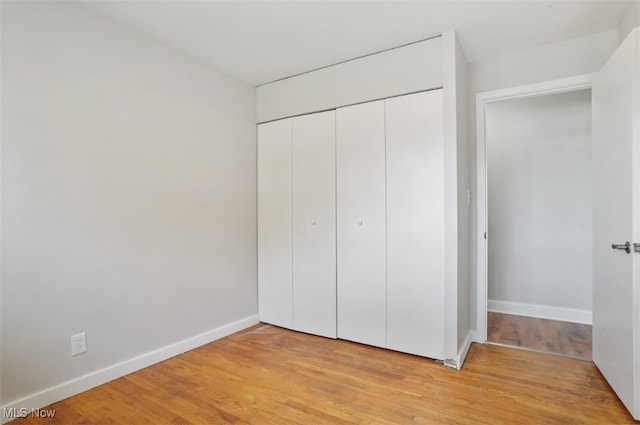 unfurnished bedroom with light hardwood / wood-style floors and a closet