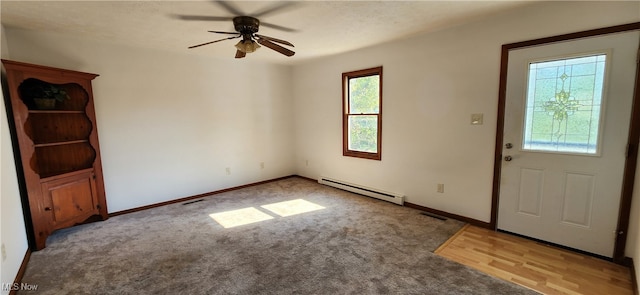 foyer with ceiling fan, baseboard heating, and light carpet