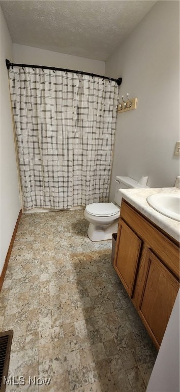 bathroom with a shower with curtain, a textured ceiling, vanity, and toilet