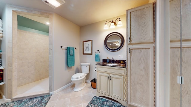 bathroom with a tile shower, toilet, tile patterned flooring, and vanity