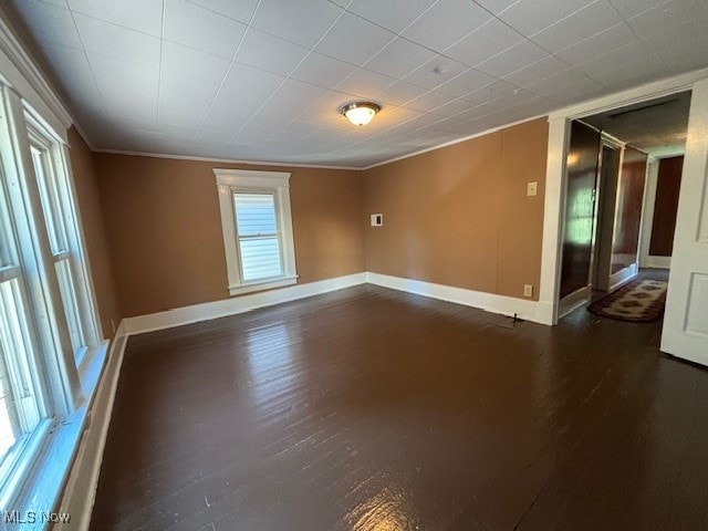 unfurnished room featuring dark hardwood / wood-style floors and crown molding