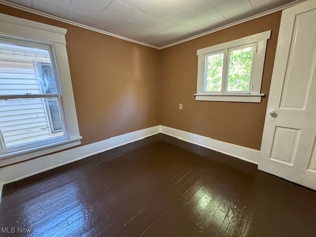 spare room with wood-type flooring and ornamental molding