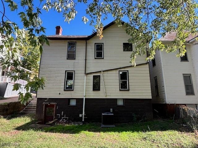 805 Quarry St, Marietta, OH 45750 - back of house with a chimney, a lawn, and central air condition unit