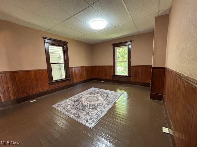 805 Quarry St, Marietta, OH 45750 - empty room with a wainscoted wall, wooden walls, a drop ceiling, and wood-type flooring