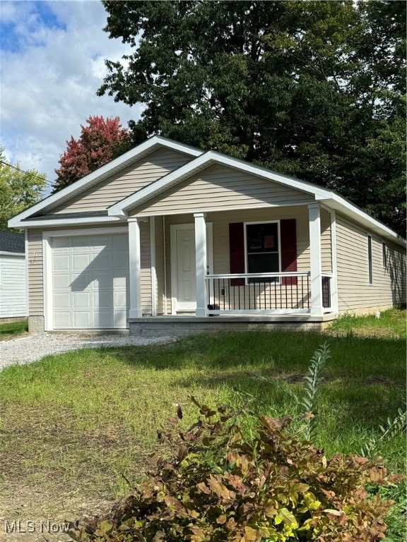 view of front of house featuring a front lawn, covered porch, and a garage