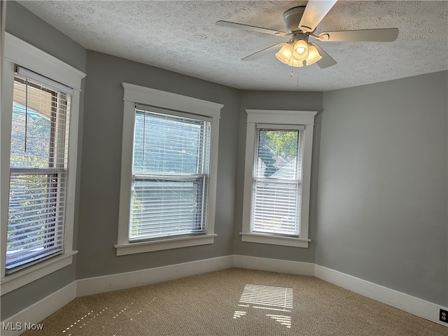 carpeted spare room with ceiling fan and a textured ceiling