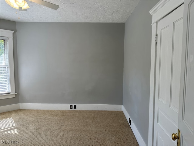 unfurnished room featuring carpet flooring, a textured ceiling, and a healthy amount of sunlight