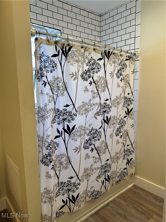 bathroom with wood-type flooring and shower / bath combo