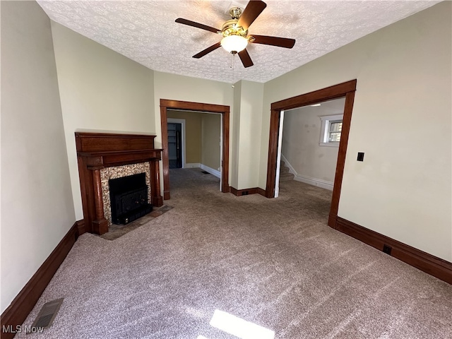 unfurnished living room with carpet floors, a textured ceiling, and ceiling fan