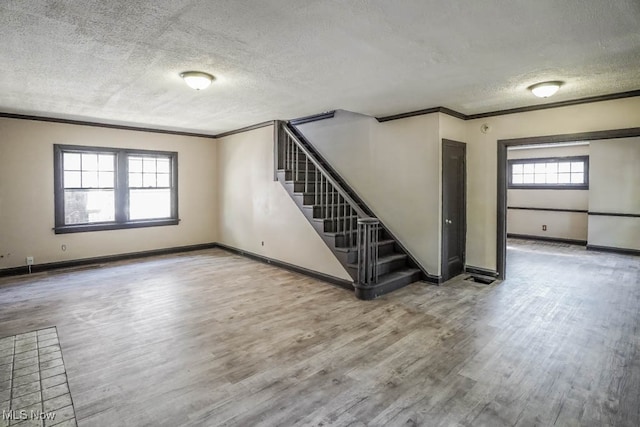 unfurnished room featuring ornamental molding, a textured ceiling, and hardwood / wood-style floors