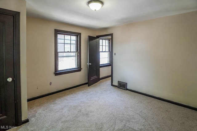 unfurnished room featuring light carpet