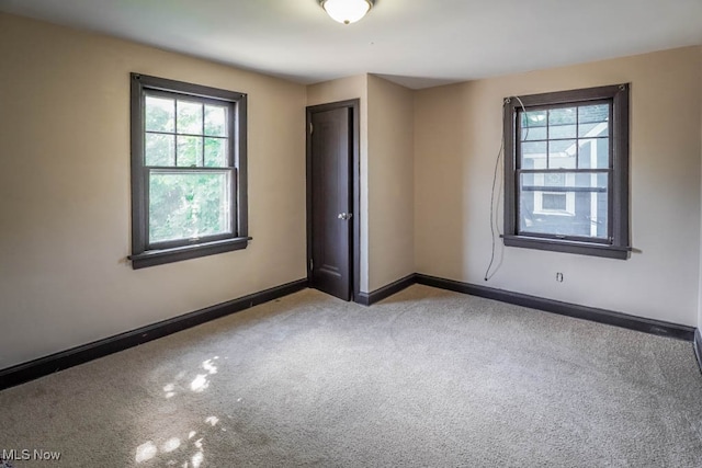 carpeted empty room with a healthy amount of sunlight