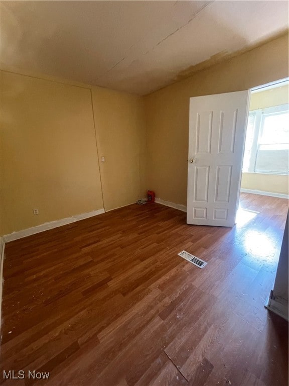 unfurnished room with hardwood / wood-style flooring