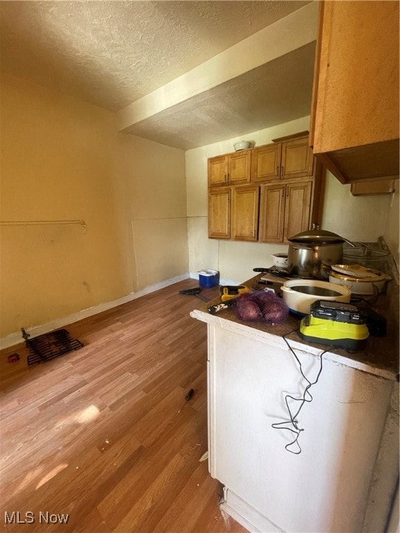 kitchen with light hardwood / wood-style flooring and a textured ceiling