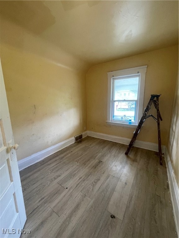 bonus room with wood-type flooring and vaulted ceiling