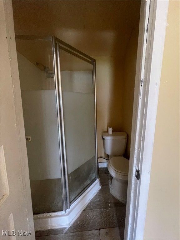 bathroom featuring hardwood / wood-style floors, toilet, and an enclosed shower