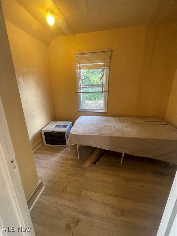 bedroom with lofted ceiling and hardwood / wood-style floors