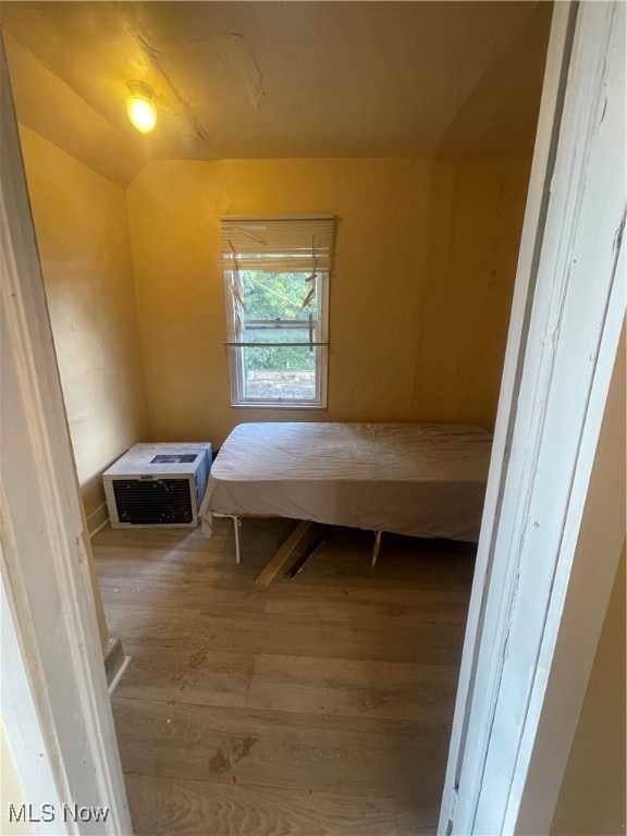 bedroom with wood-type flooring and vaulted ceiling