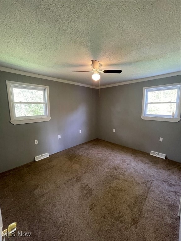 empty room featuring ornamental molding, carpet, a textured ceiling, and ceiling fan