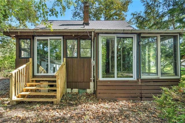 rear view of house featuring a sunroom