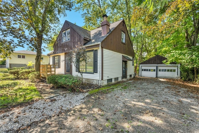 view of side of home featuring a garage and an outdoor structure