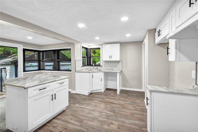 kitchen with hardwood / wood-style floors, sink, and white cabinetry