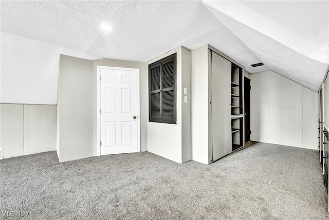 bonus room featuring light colored carpet, a textured ceiling, and vaulted ceiling