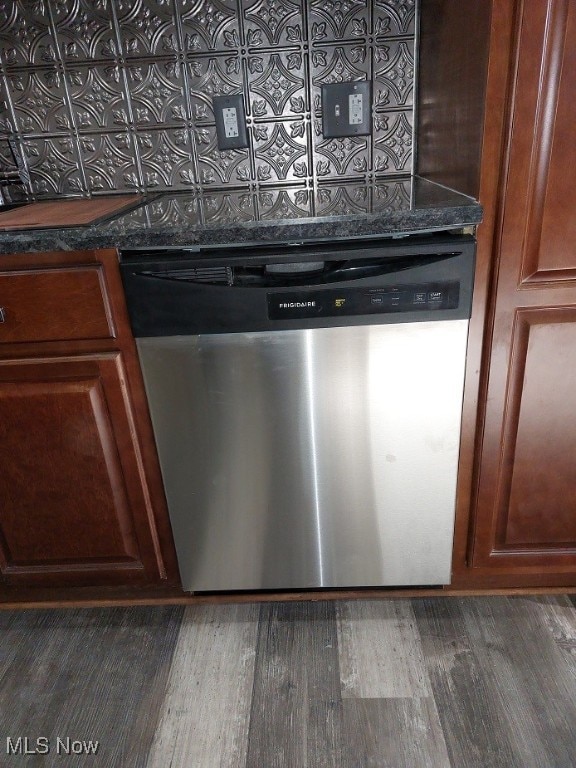 interior details featuring dishwasher, dark stone counters, and dark hardwood / wood-style flooring