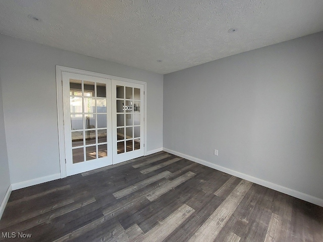 empty room with french doors, dark hardwood / wood-style floors, and a textured ceiling