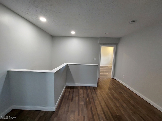 unfurnished room featuring a textured ceiling and dark wood-type flooring