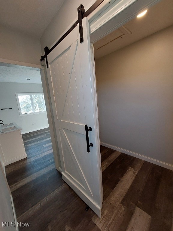 staircase featuring a barn door, hardwood / wood-style floors, and sink