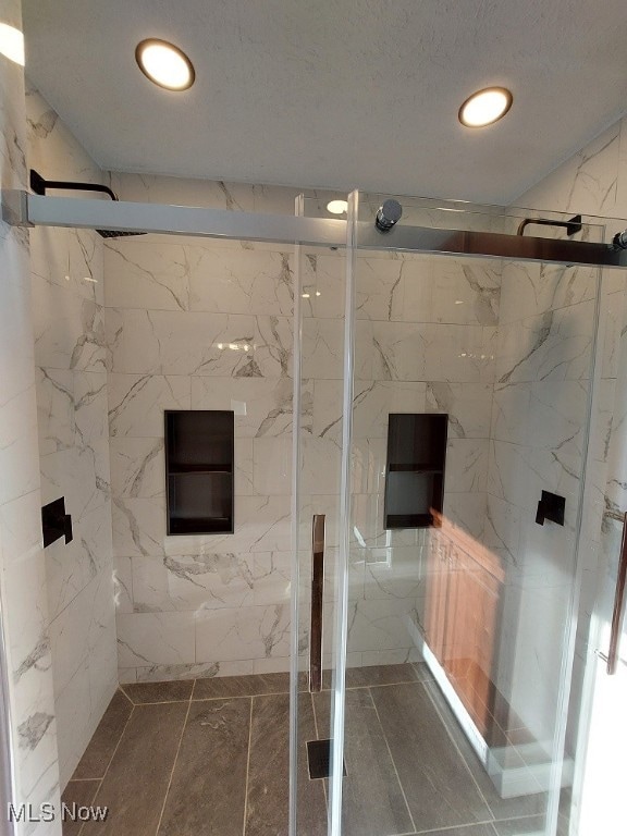 bathroom with a shower with door