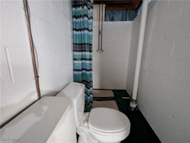 bathroom featuring toilet and curtained shower