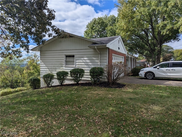 view of side of home with a garage and a yard