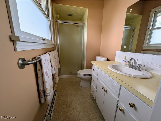 bathroom featuring vanity, toilet, and a shower with door