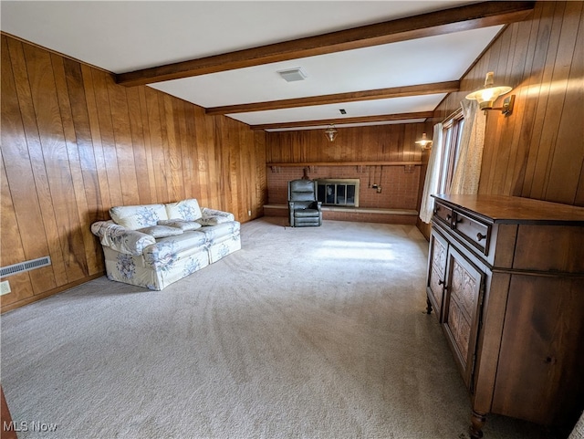 unfurnished living room with light carpet, beamed ceiling, and wood walls