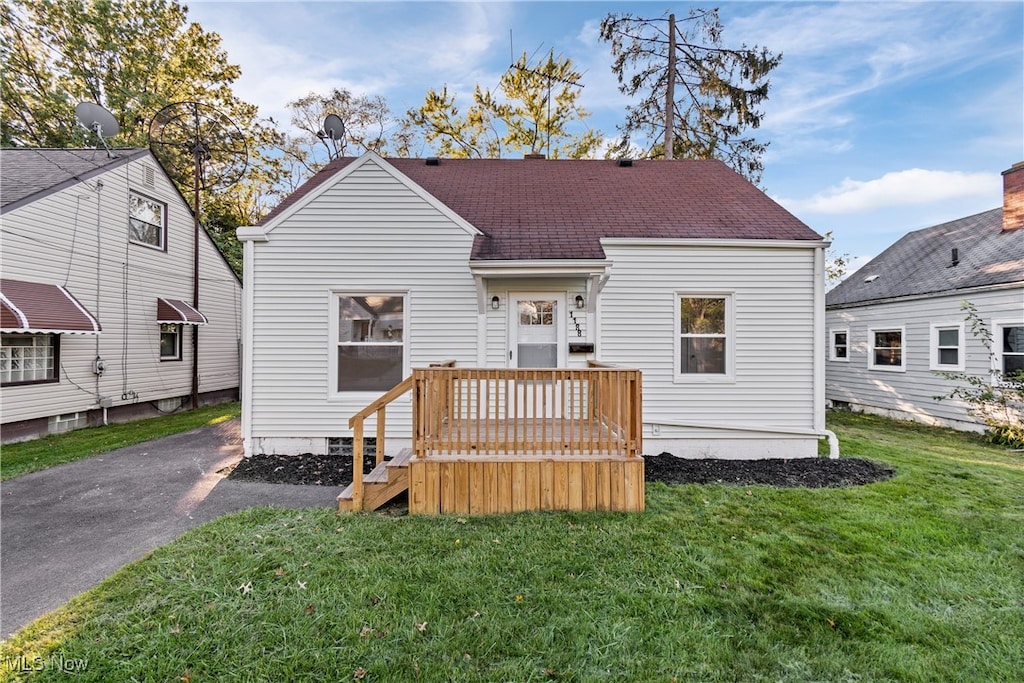 back of property featuring a lawn and a deck