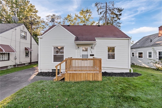 back of property featuring a lawn and a deck