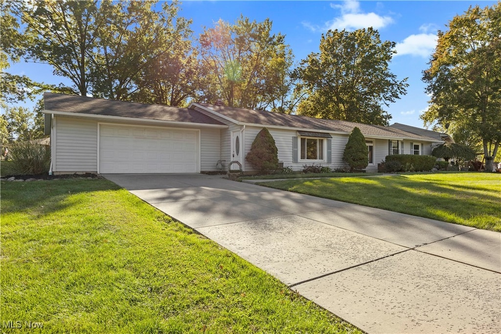 ranch-style house featuring a garage and a front yard